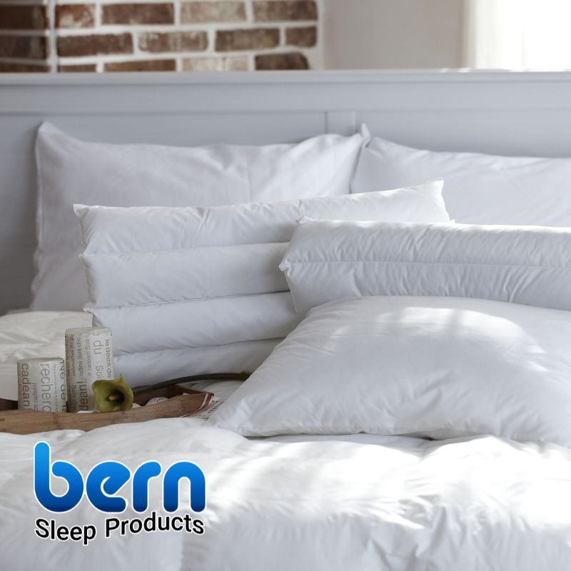 دو بالش سفید و تازه شسته شده روی تخت که نشان‌دهنده مراقبت و تمیزی منظم بالش‌ها میباشد